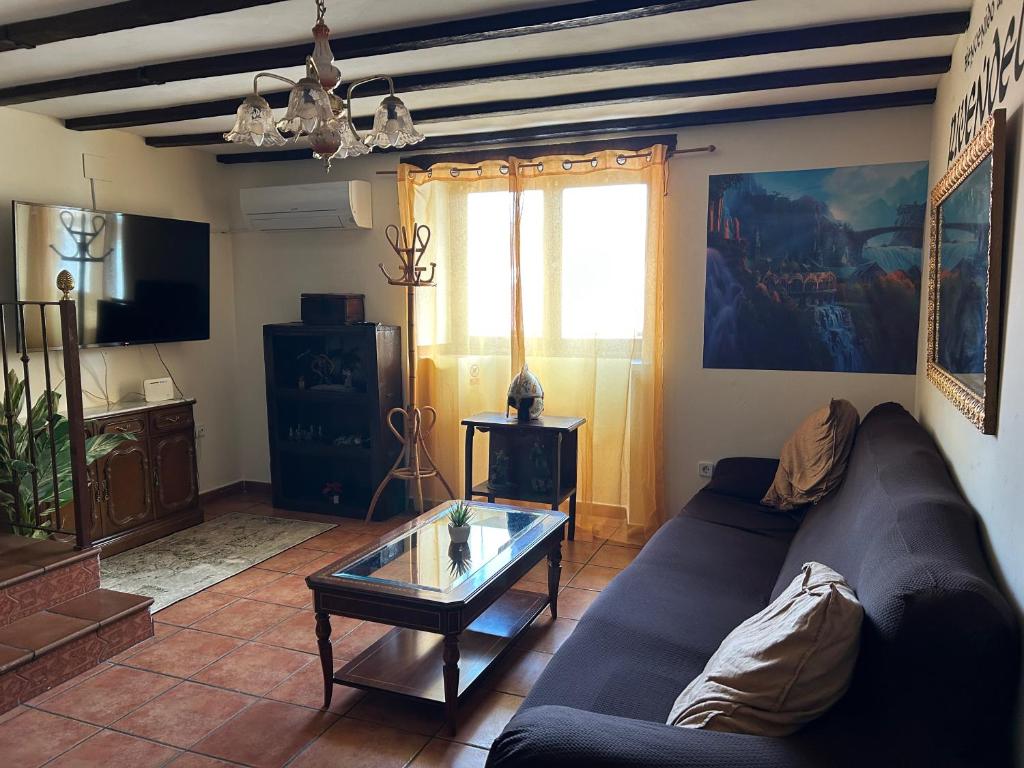 a living room with a couch and a glass table at Casa Rivendel - Fantasía, Confort y Naturaleza in Poyales del Hoyo