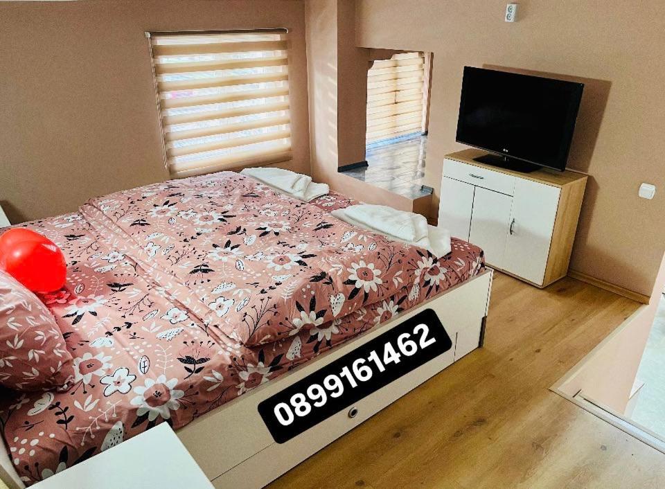 een slaapkamer met een bed en een flatscreen-tv bij Апартамент за гости Николови in Vidin