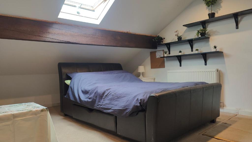 a bedroom with a bed with purple sheets and a window at Edwardian House in Manchester