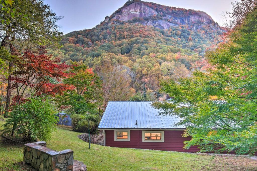 a red house with a mountain in the background at The Red Rock Retreat in Chimney Rock