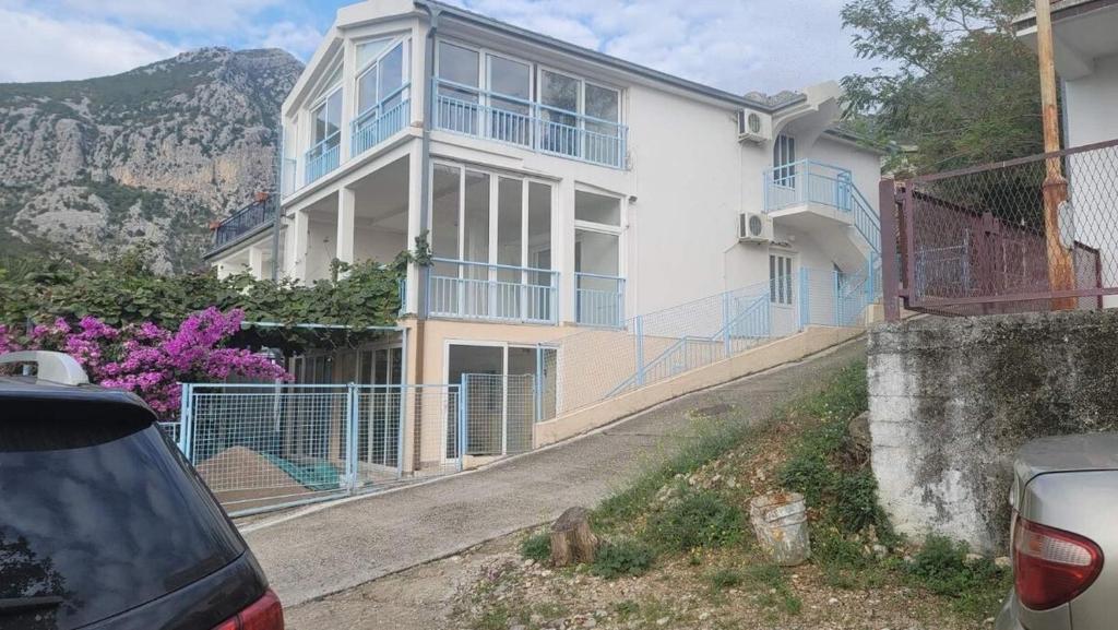 a large white house with blue balconies on a street at Villa Mirijana in Zlatna Obala