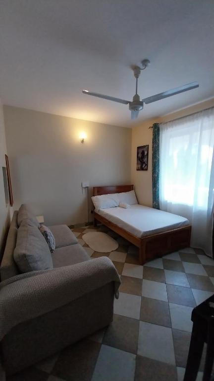 a living room with a couch and a bed at Makao in Kilifi