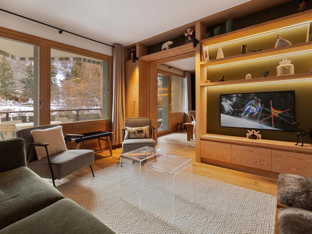 un salon avec un canapé et une télévision dans l'établissement Appartement rénové proche pistes, terrasse spacieuse - FR-1-808-21, à La Salle Les Alpes