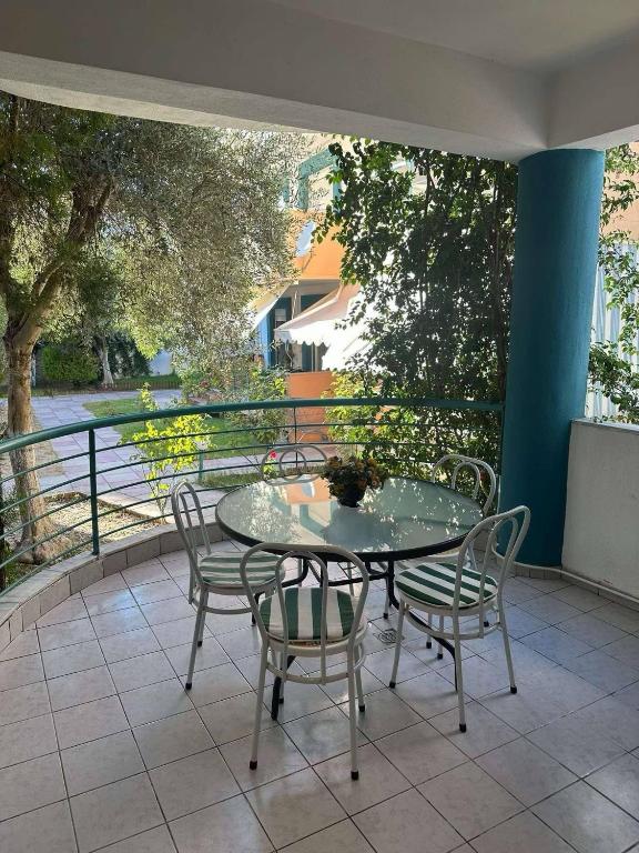 un patio con tavolo e sedie su un balcone di Nikoletas Apartment Pefkochori a Pefkohori
