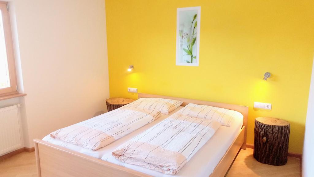 two beds in a room with a yellow wall at Agriturismo Ferienhof Gschloier - Adults only in Laion