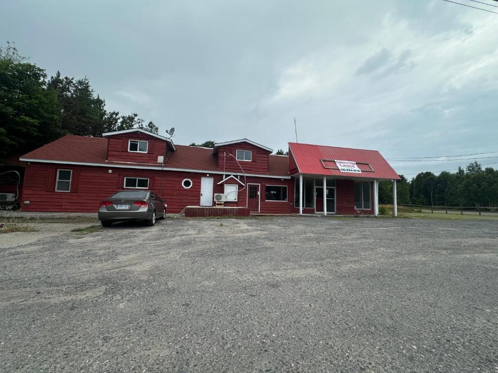 a red house with a car parked in front of it at Thessalon Luxury House -Space Share in Thessalon