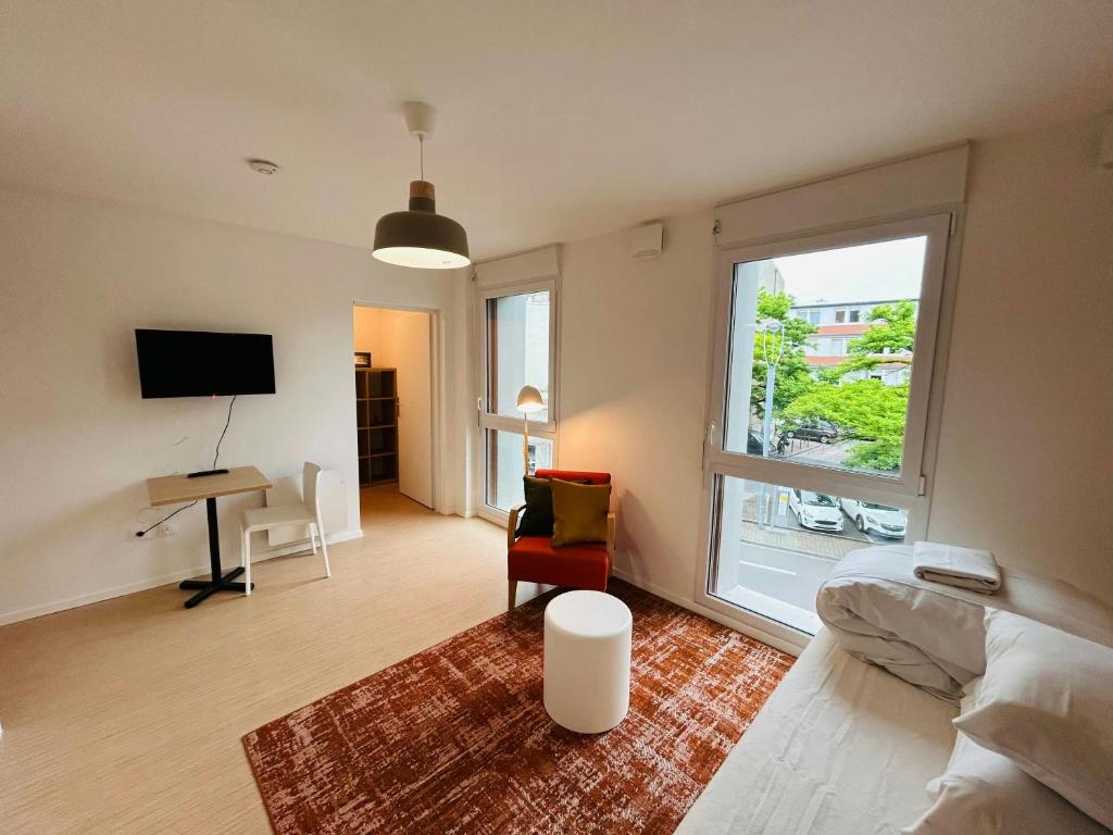 a bedroom with a bed and a desk and a window at We Live In R - Suite 204 in Reims