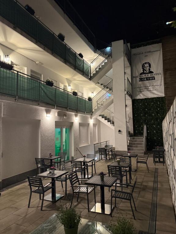a patio with tables and chairs at night at Boutique-Hotel Goethe in Munich