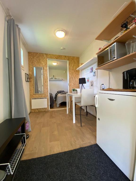 a kitchen with a white refrigerator and a table at Huilikammari in Seinäjoki
