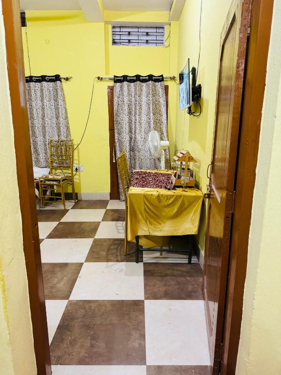 a dining room with a table and a yellow wall at bagga villa in Patna