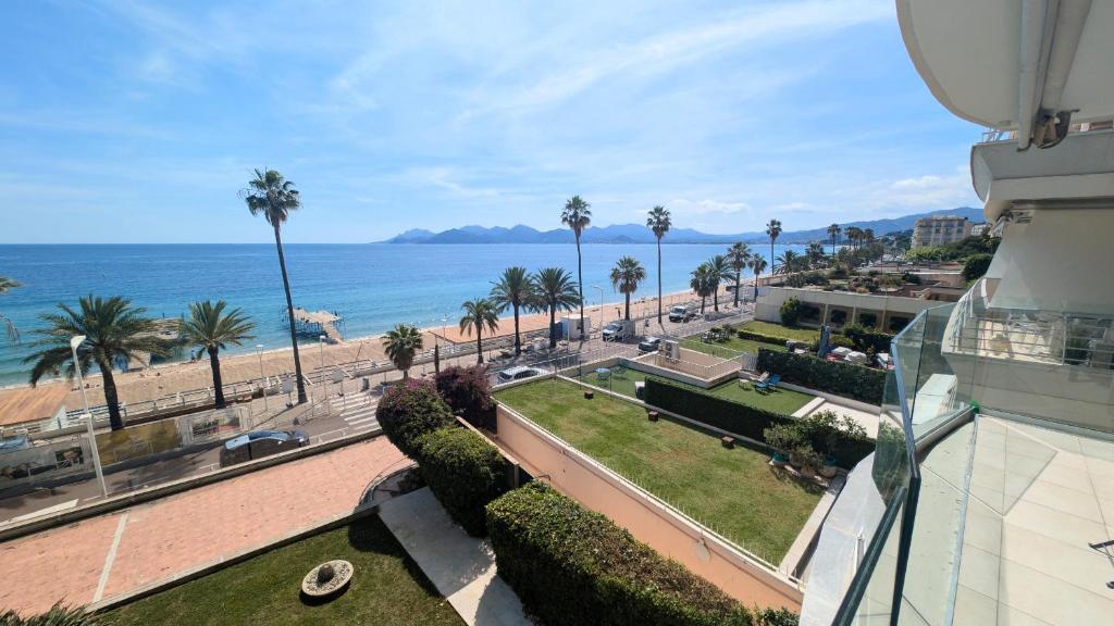 une vue sur une plage et l'océan depuis un immeuble dans l'établissement Ref BELLAMARE, à Cannes
