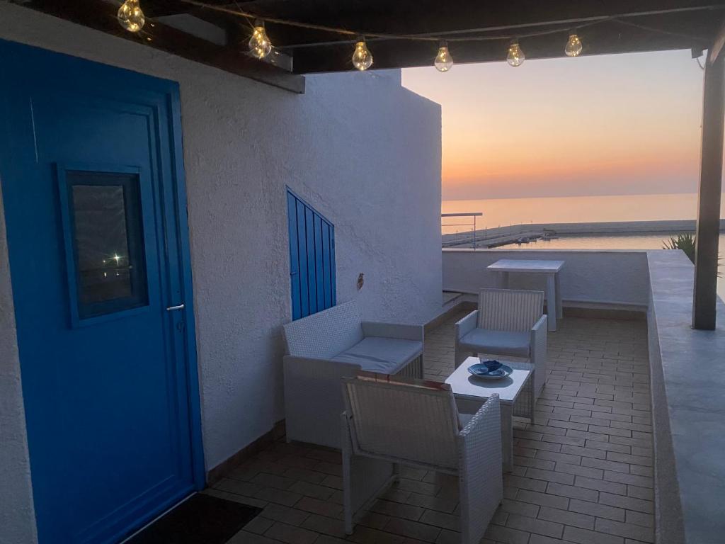 a patio with a blue door and a table and chairs at Baia Marina Oasi in Balestrate