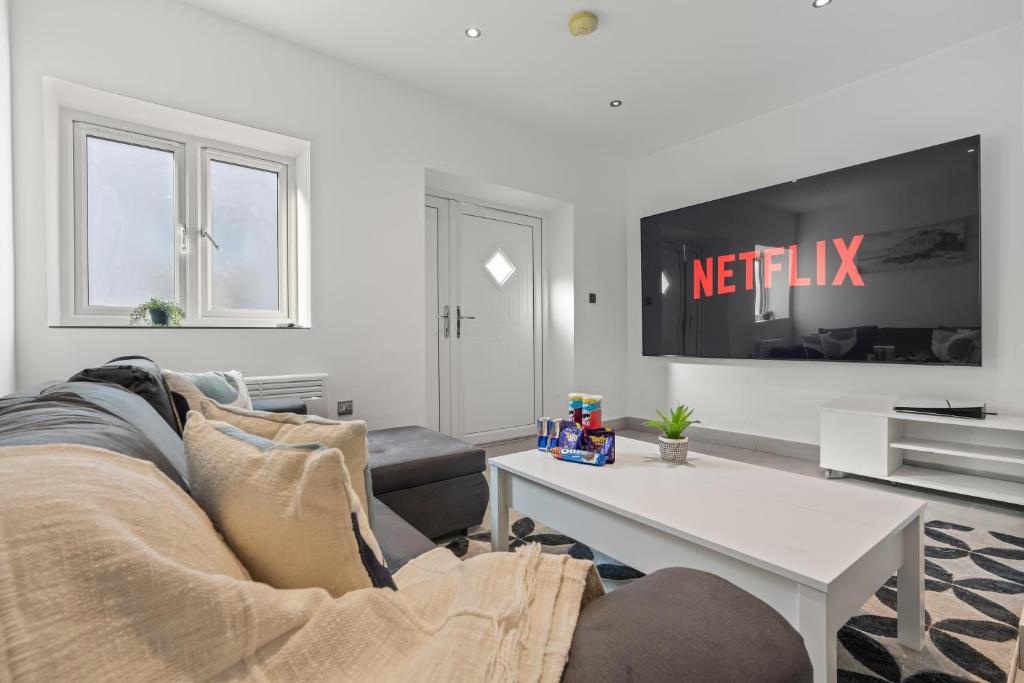 un salon avec un canapé et une télévision dans l'établissement Cinema Studio Room with Spa, à Cardiff