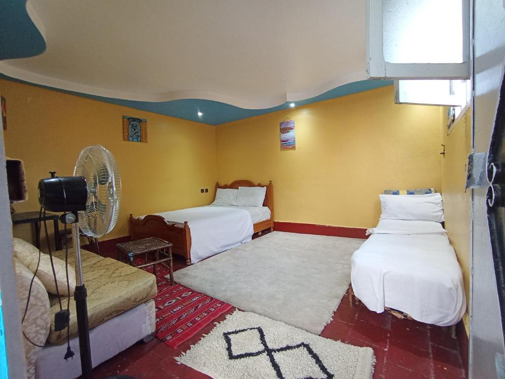 a hotel room with two beds and a fan at Sunset rooftop Rabat Sale Airport in Sale