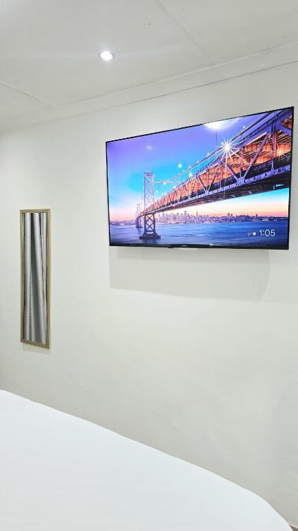 a flat screen tv hanging on a white wall at HMT Exquisite Spaces in Polokwane
