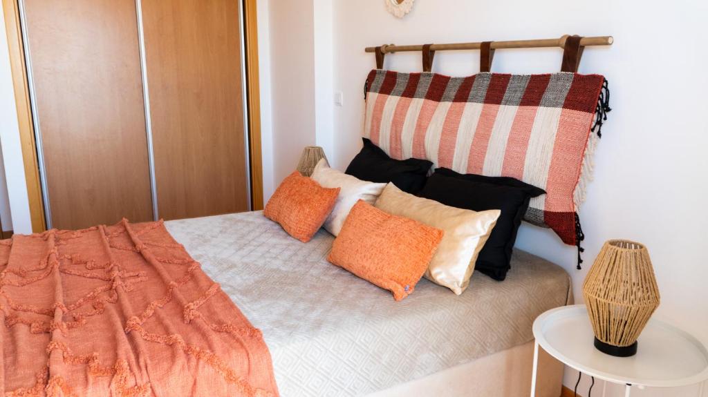 Un dormitorio con una cama con almohadas encima. en Pandora House, en Nazaré