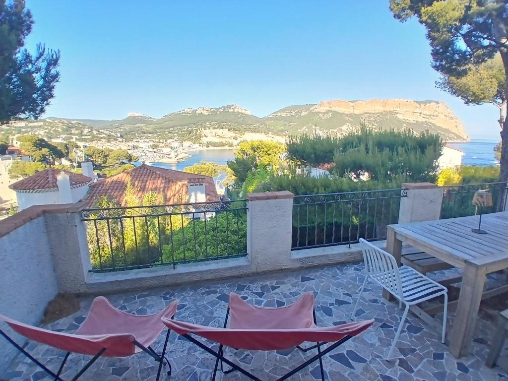 un patio avec une table et des chaises et une vue dans l'établissement Maison 6 personnes, Vue Mer avec jardin, barbecue, paddle, à Cassis