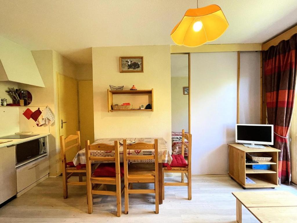 une cuisine et une salle à manger avec une table et des chaises dans l'établissement Résidence Jetay - Appartement 4 personnes avec vue sur la montagne MAE-5604, aux Menuires