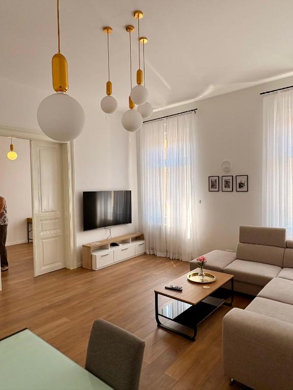 a living room with a couch and a tv at La Perla Centre in Zagreb