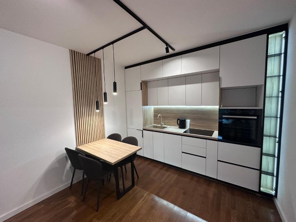 een keuken met een tafel en stoelen in een kamer bij Apartman Spring Premium with Garage in Sarajevo