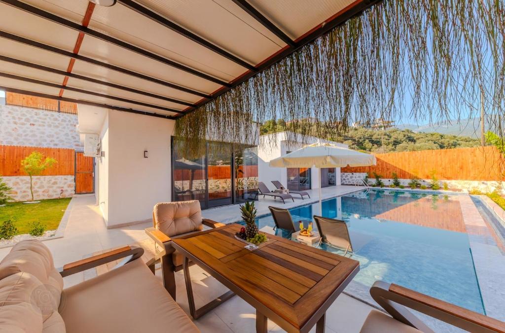 ein Wohnzimmer mit einem Tisch und einem Pool in der Unterkunft Holidays are the best days, villa vacation is great in Çavdır