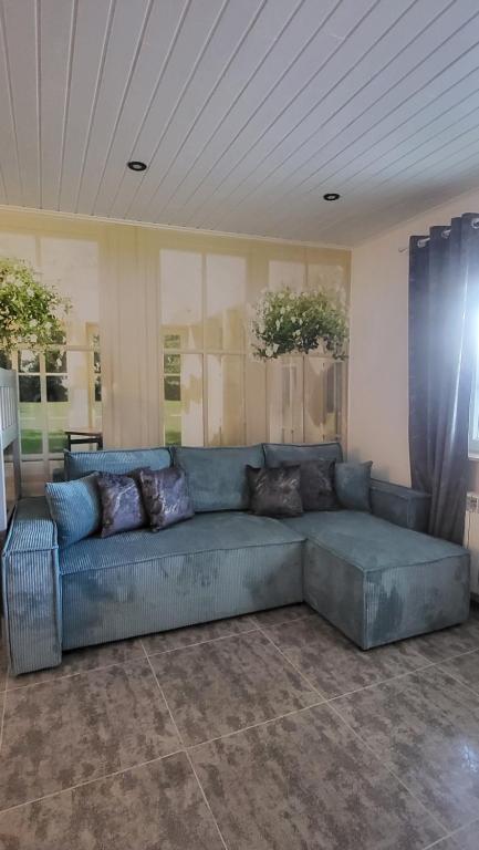a large blue couch in a living room at Lawendowy dworek in Paszowa