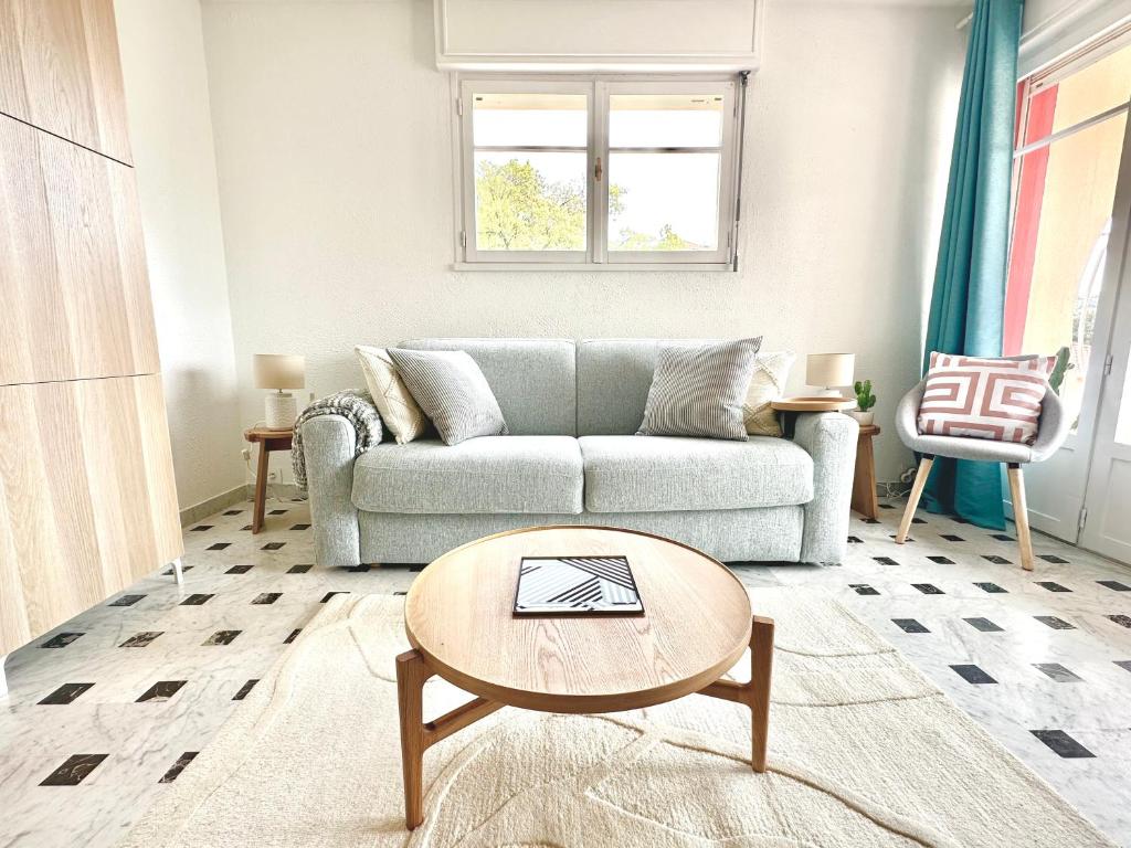 una sala de estar con un sofá y una mesa en Superbe 4 couchages avec terrasse - Clim - 50m de la mer, en Saint-Raphaël