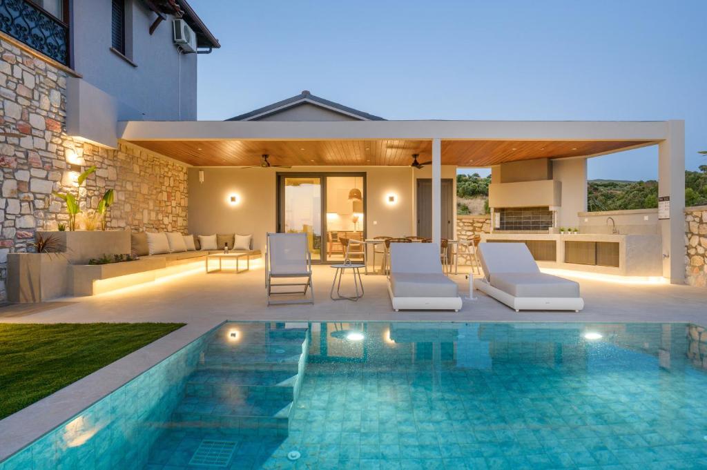 a villa with a swimming pool and a house at Thea Suites in Ouranoupoli