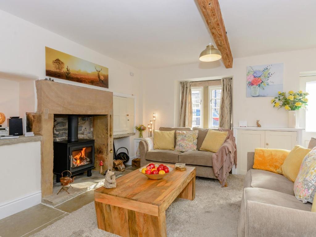 a living room with a couch and a fireplace at Whibberley Cottage in Ashford