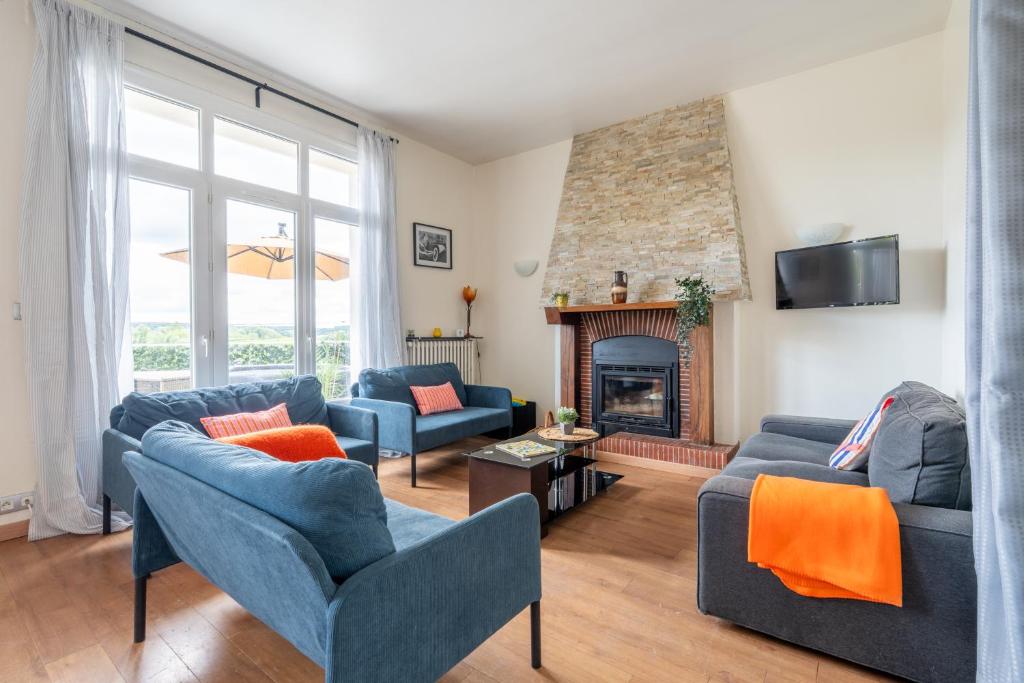 a living room with blue couches and a fireplace at Appart 10personnes Terrasse vue Loire, Parkings Voitures Vélos,10min Centre Blois,40min Zoo Beauval in Blois