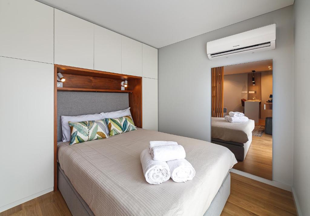 a bedroom with a bed with towels on it at Seagull Lodge incl Parking by Home Sweet Home Aveiro in Aveiro