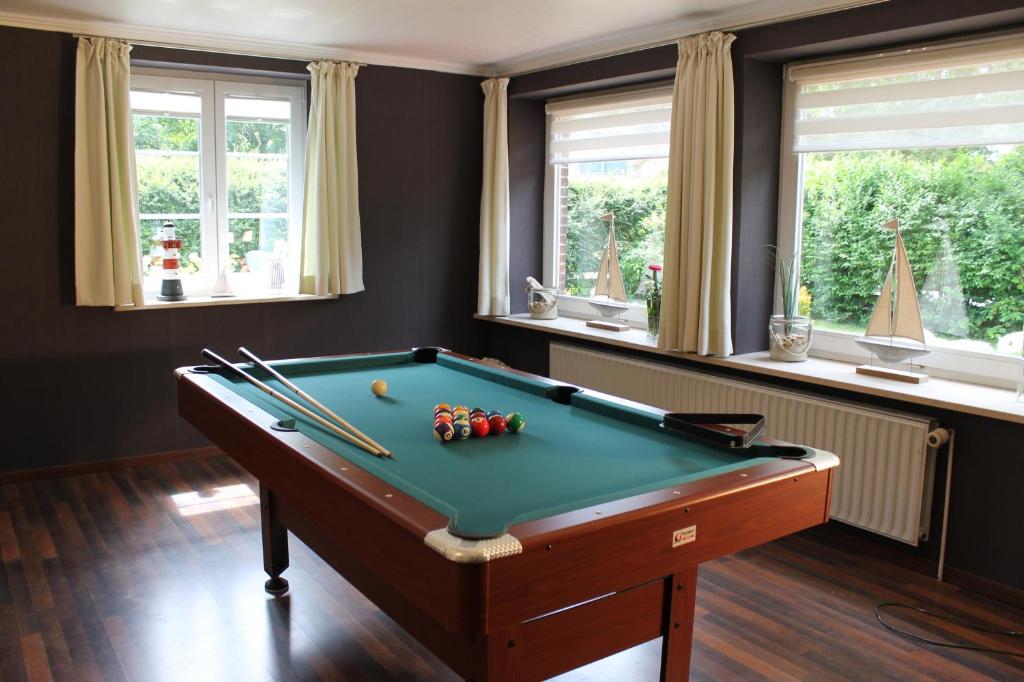 Habitación con mesa de billar y ventanas en Ferienhaus Nadja, en Westerland