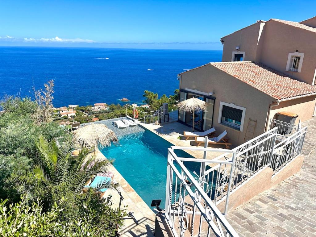 a house with a swimming pool next to the ocean at Villa Naïma Esterel in Saint-Raphaël