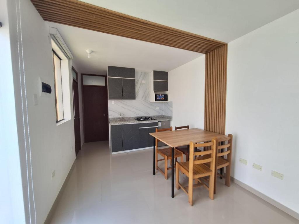 a kitchen with a wooden table in a room at casa completa huanchaco con estacionamiento EL REFUGIO SECRETO in Huanchaco