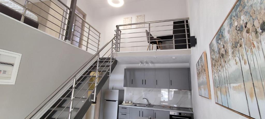 a kitchen with a staircase with a dog in a cage at Modern House Close to the Sea Asprovalta in Asprovalta