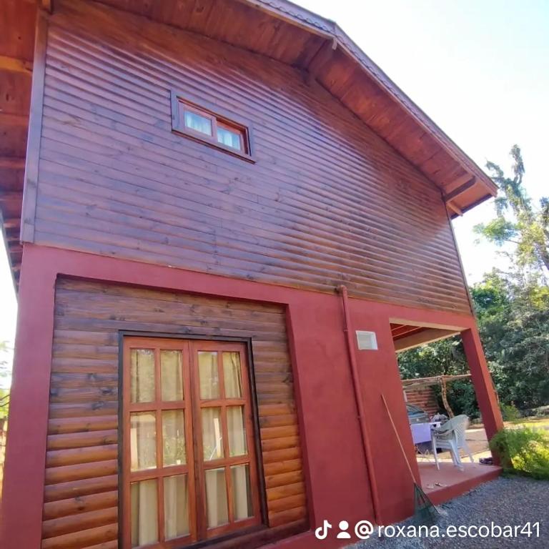 eine Blockhütte mit zwei Türen und einem Fenster in der Unterkunft Cabañas Flores de Lapacho Iguazu in Puerto Iguazú
