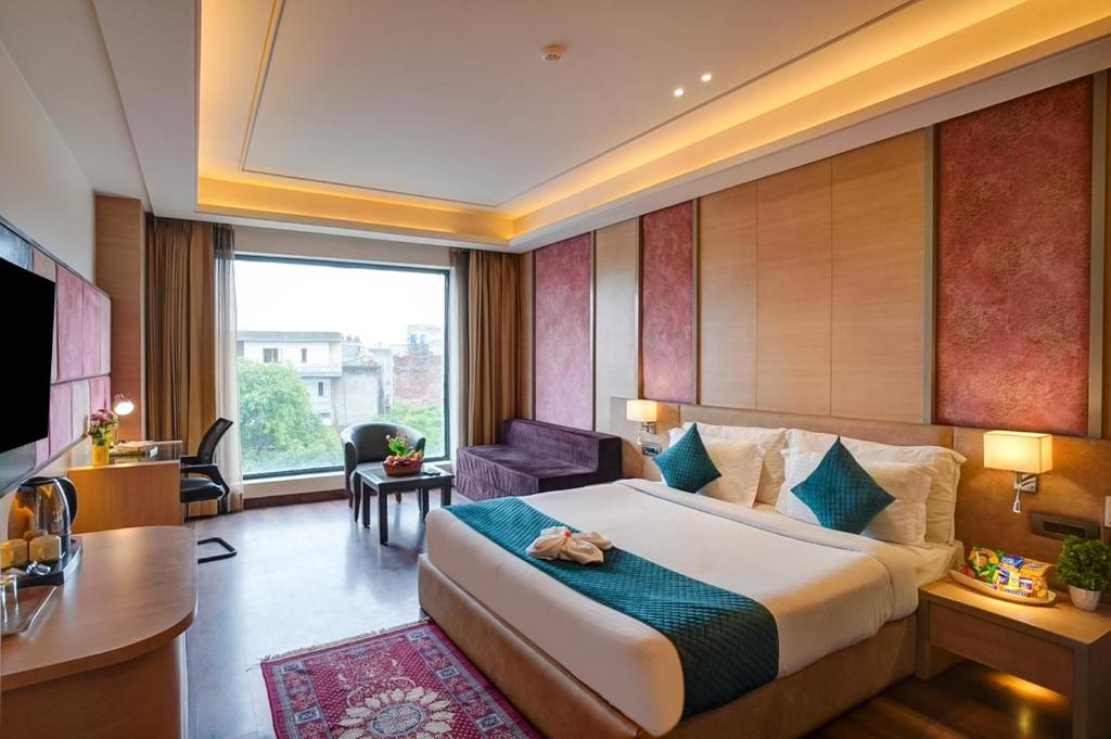 een hotelkamer met een groot bed en een bureau bij SANDOZ Pribson Hotel near Golden Temple in Amritsar