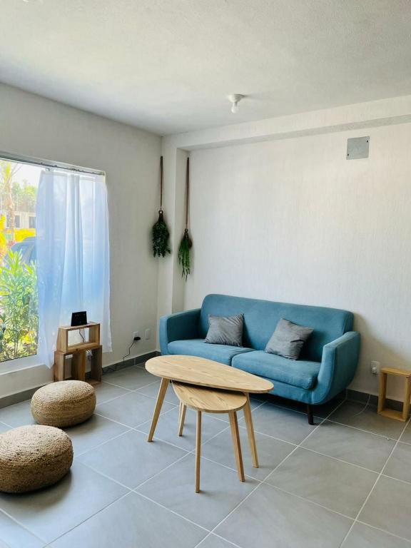 a living room with a blue couch and a table at Puerta al Sol in Acapulco