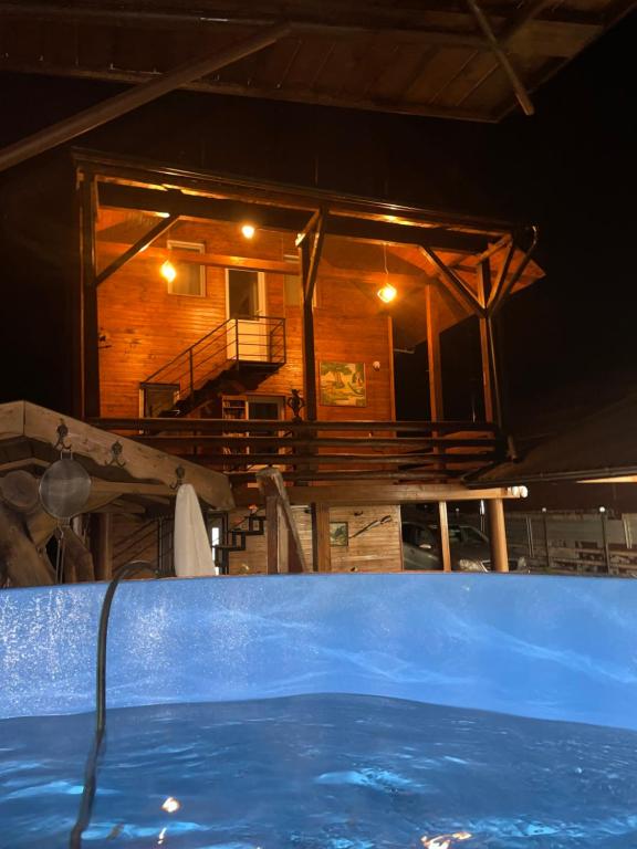 une grande baignoire bleue devant une maison en bois dans l'établissement Cabana Revnic, à Băişoara
