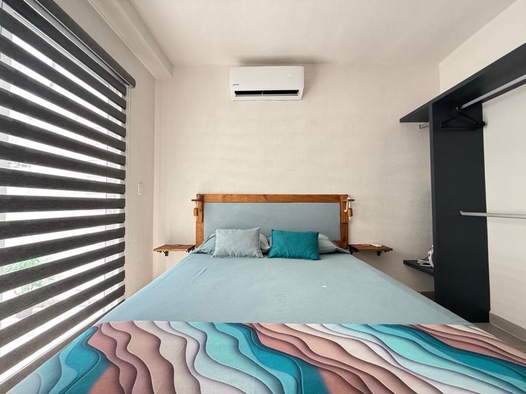 a bedroom with a bed with a colorful blanket at Puerta al Sol in Acapulco