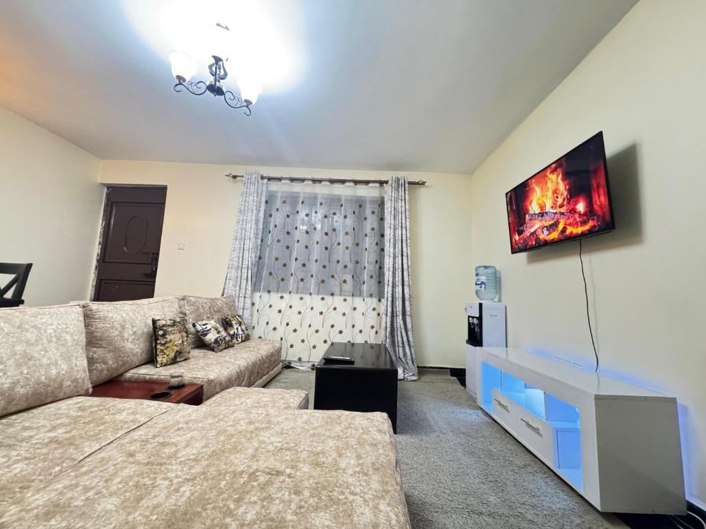 een woonkamer met een bank en een tv bij Executive homes in Kitengela 