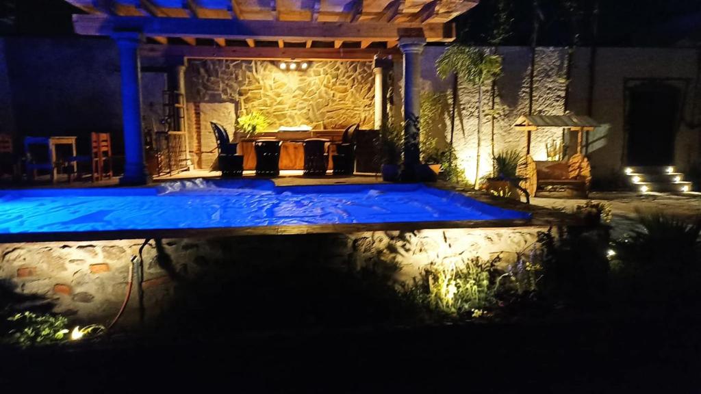 a swimming pool in a yard at night at Casa de Campo luciérnaga in San Miguel de Allende