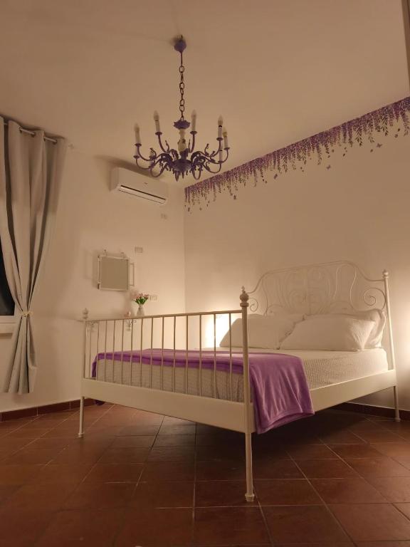 a bedroom with a white bed and a chandelier at Casa Marisa in Taranto