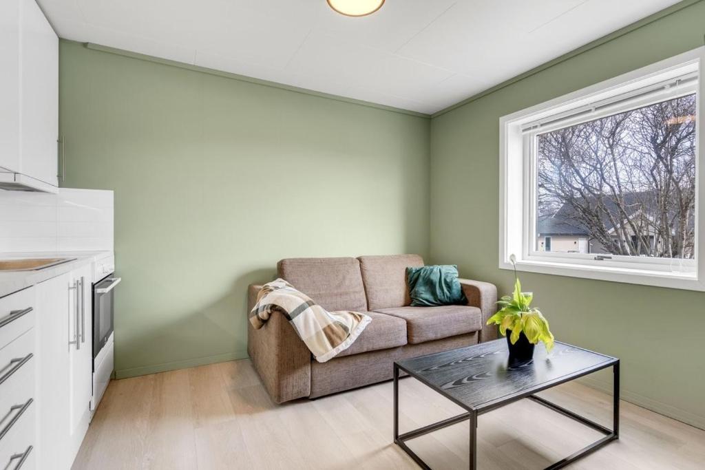una sala de estar con un sofá y una mesa en Nice apartment on Futrikelva, en Tromsø