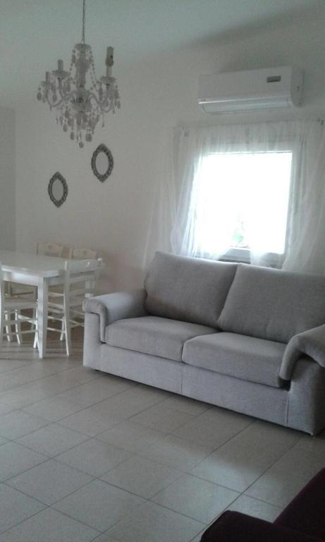 Biały salon z kanapą i stołem w obiekcie Il Fenicottero Rosa w mieście Olbia