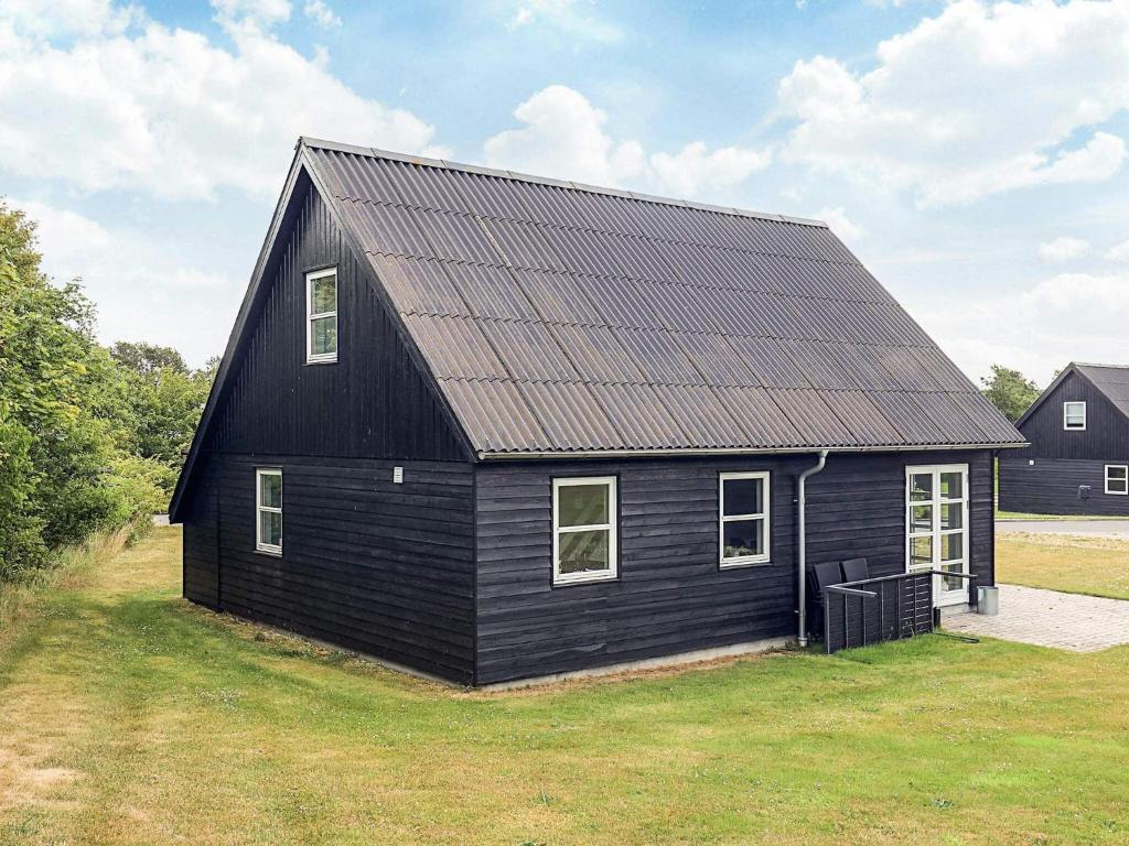 a black house with a metal roof at 5 star holiday home in Farsø in Farsø