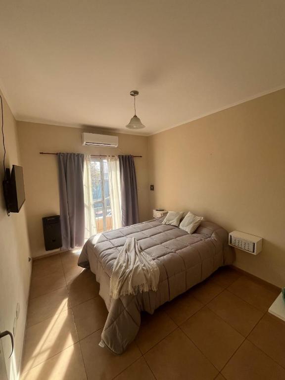 a bedroom with a large bed and a window at Departamento Naon SP in San Pedro