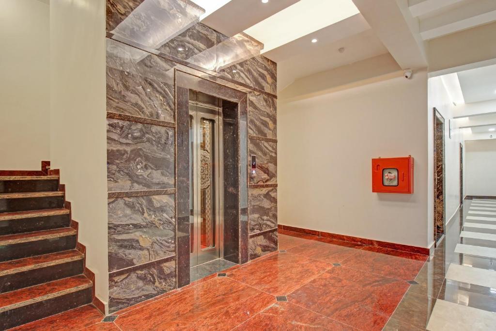 Un pasillo con escaleras y una pared de piedra. en Super Townhouse OAK VS Shivanya, en Lucknow