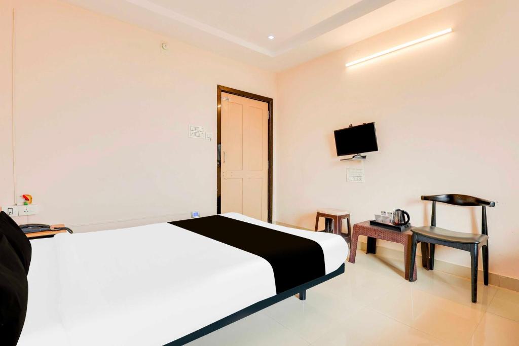 a bedroom with a bed and a tv on the wall at Hotel O Kakinada near JNTU in Kākināda
