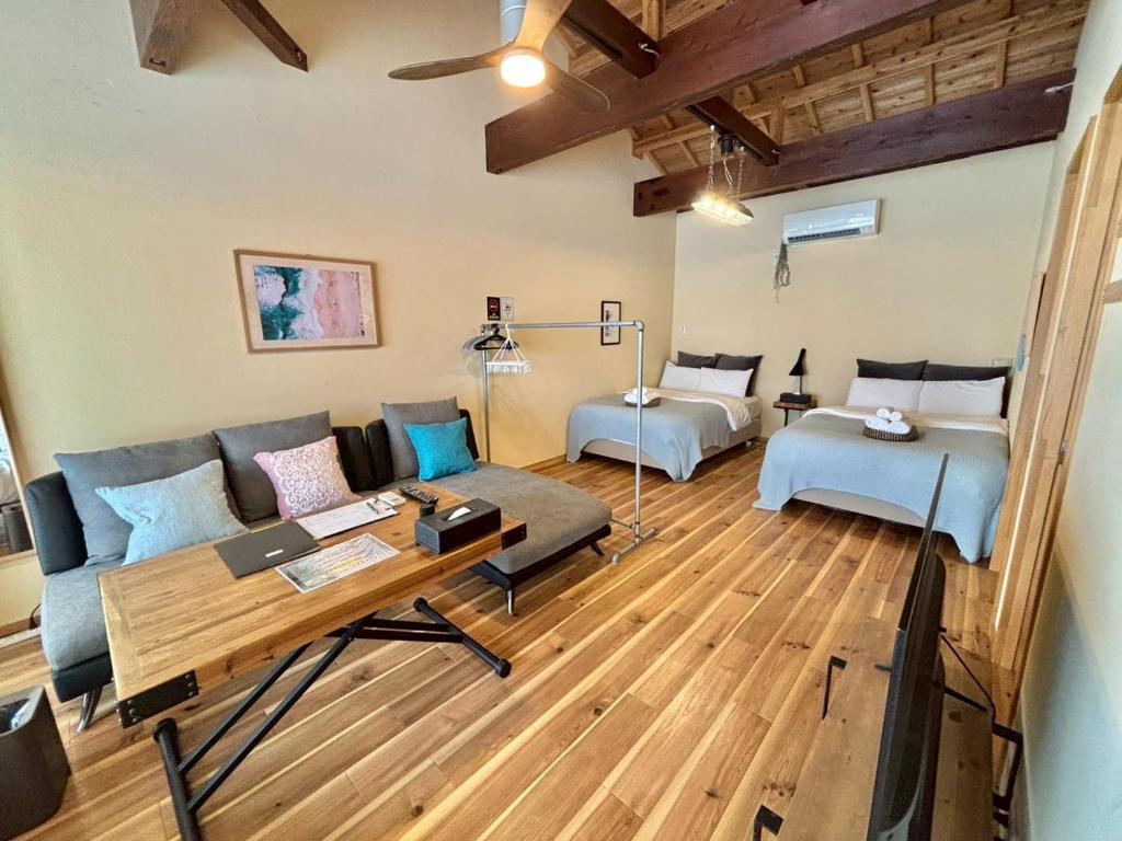 een woonkamer met een bank en een tafel bij RED ROOF ISHIGAKI in Ishigaki Island